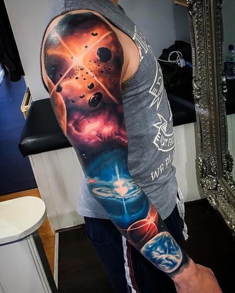 a man is standing in front of a mirror with tattoos on his arm and shoulder