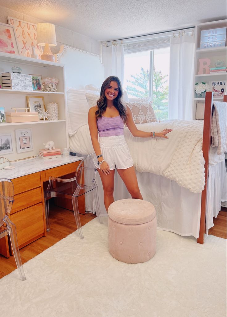 a woman standing in front of a white bed