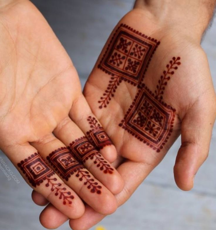 two hands with hendi tattoos on them holding each other's palms and fingers