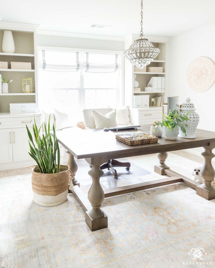 a living room filled with furniture and a large table in front of a window on top of a rug