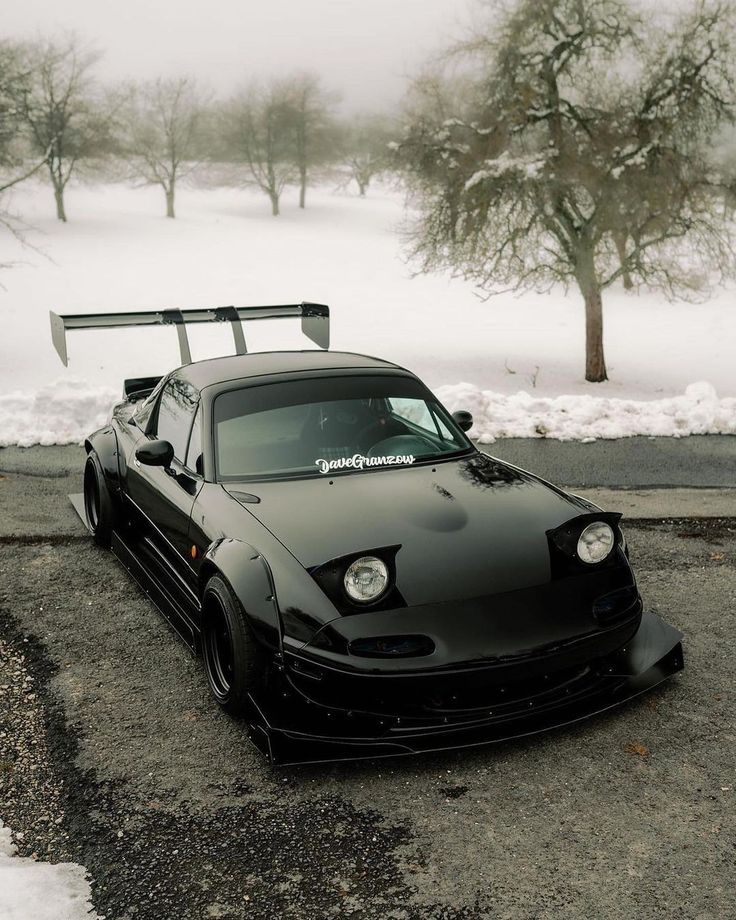 a black sports car parked in the snow