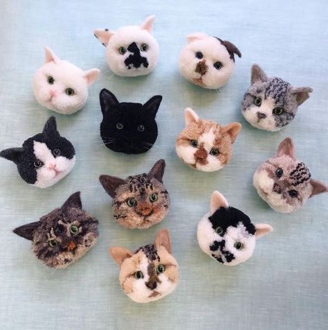 there are many small stuffed cats on the table with one cat looking at the camera