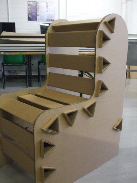 a chair made out of cardboard sitting in a room