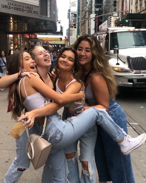 four girls hugging each other on the street