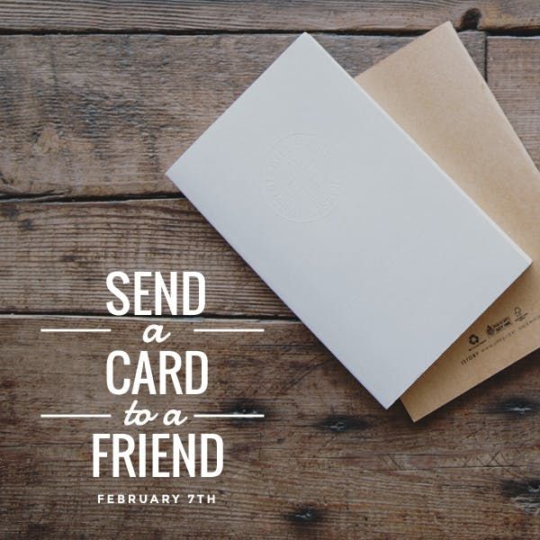 two white envelopes sitting next to each other on top of a wooden table with the words send a card to a friend