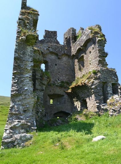 an old stone castle sitting on top of a lush green field