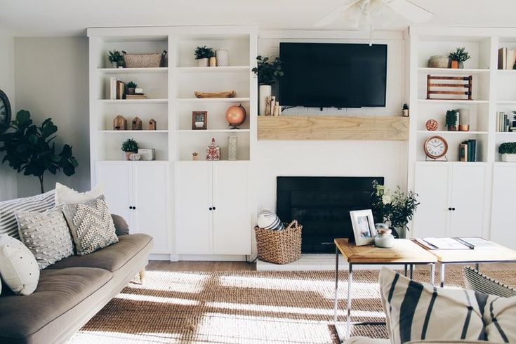 a living room filled with furniture and a flat screen tv mounted to a wall above a fire place