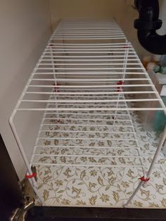 a white metal rack sitting on top of a tiled floor