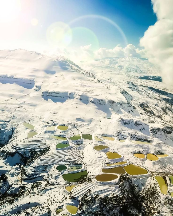 an aerial view of snow covered mountains and lakes