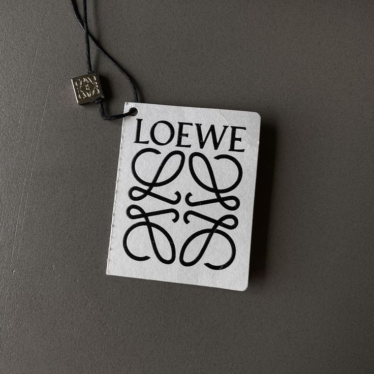 a black and white book with the words loewe on it hanging from a cord