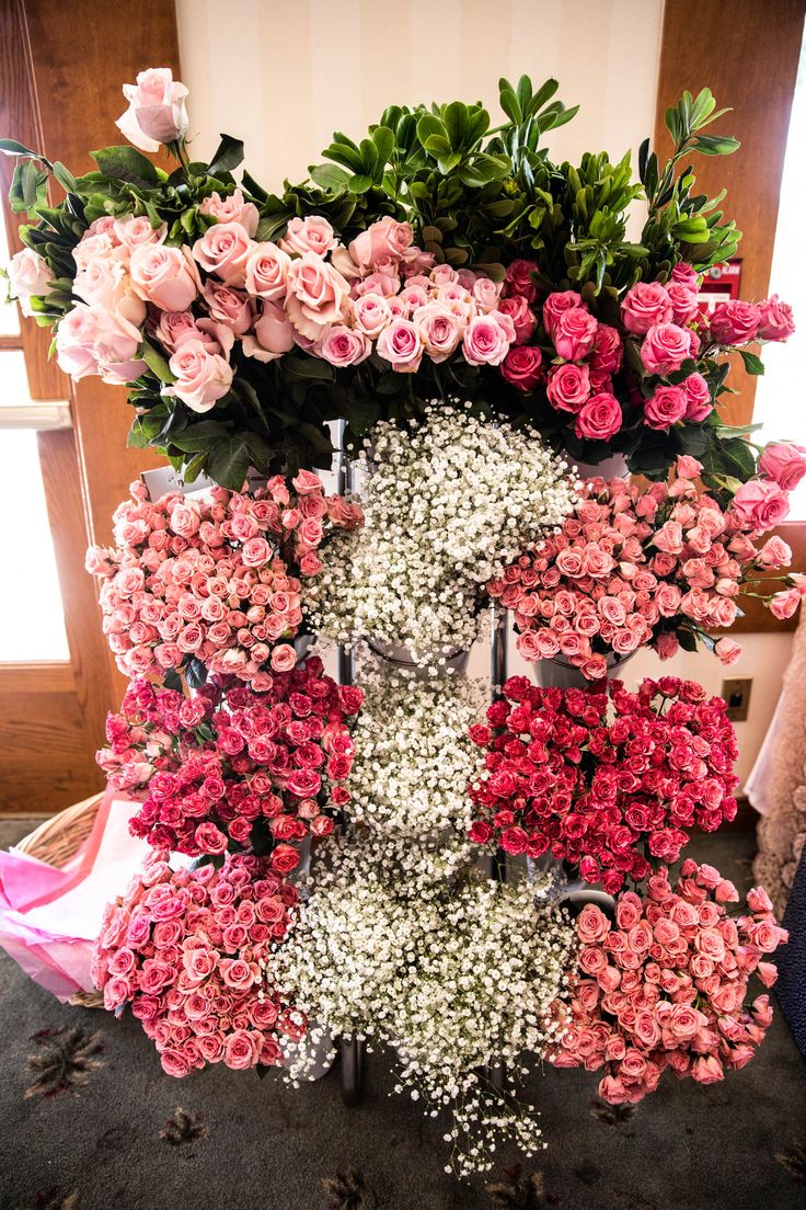 pink and white flowers are arranged in the shape of a letter