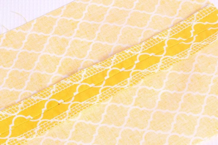 two pieces of fabric with yellow and white designs on them, next to each other