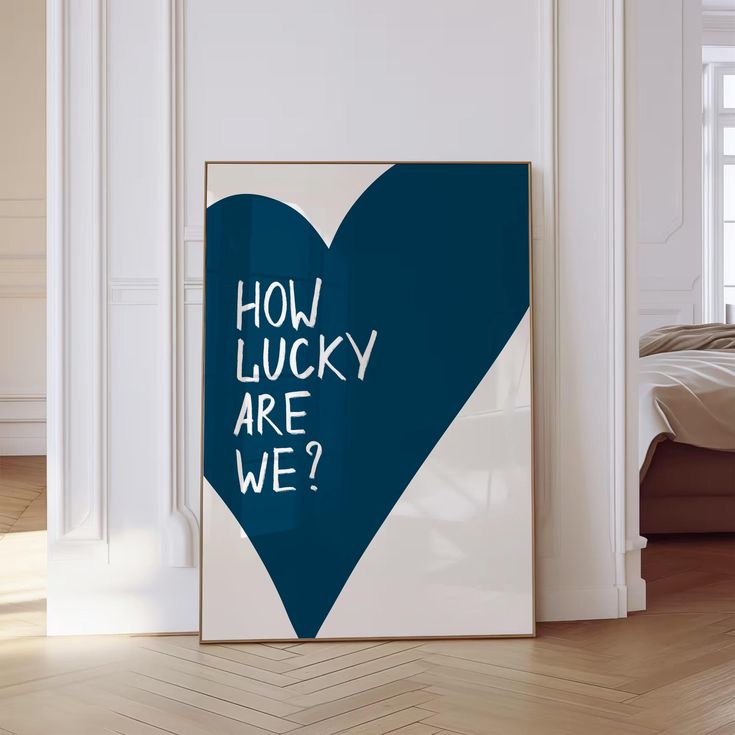 a blue heart with the words how lucky are we? on it in front of a white wall