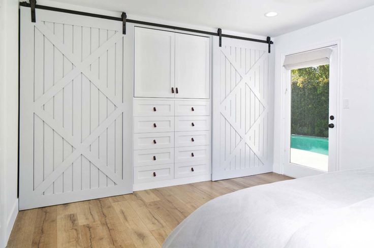 a bedroom with white walls and sliding doors