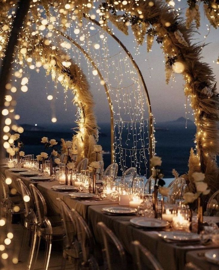 an outdoor dining area decorated with lights and pamolite garlands for a wedding reception