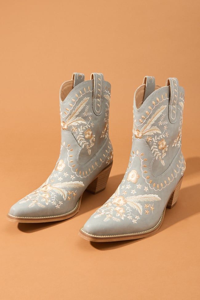 Delicate florals dance across these boots, adding a touch of unique personality and charm. The classic pointed toe and stacked heel nod to the timeless style of the Wild West. Western Boots With Floral Print For Fall, Bohemian Snip Toe Boots For Spring, Bohemian Snip Toe Spring Boots, Spring Bohemian Snip Toe Boots, Embroidered Pointed Toe Boots For Fall, Fall Floral Embroidered Snip Toe Boots, Elegant Embroidered Pointed Toe Boots, Fall Floral Embroidery Snip Toe Boots, Spring Boots With Stacked Heel And Snip Toe