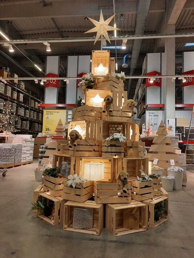 a christmas tree made out of wooden pallets in a warehouse with lights on top