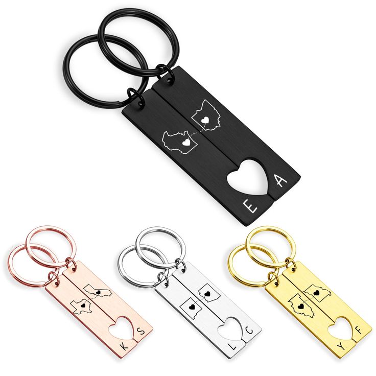 four different colored metal keychains with black, white, and gold tags attached to them