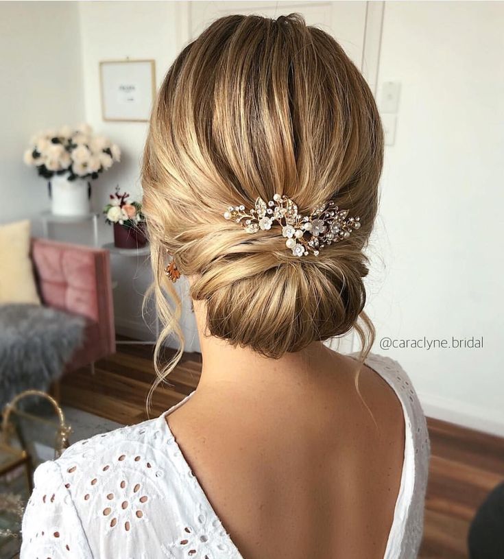 the back of a woman's head with hair in a low bun and two small pearls on it