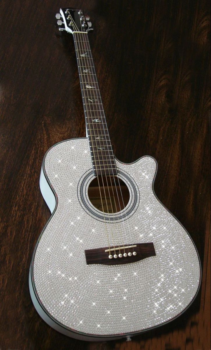 an acoustic guitar sitting on top of a wooden table