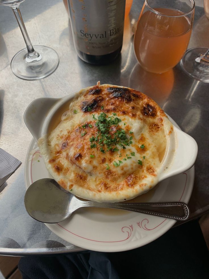 a white plate topped with food next to two wine glasses