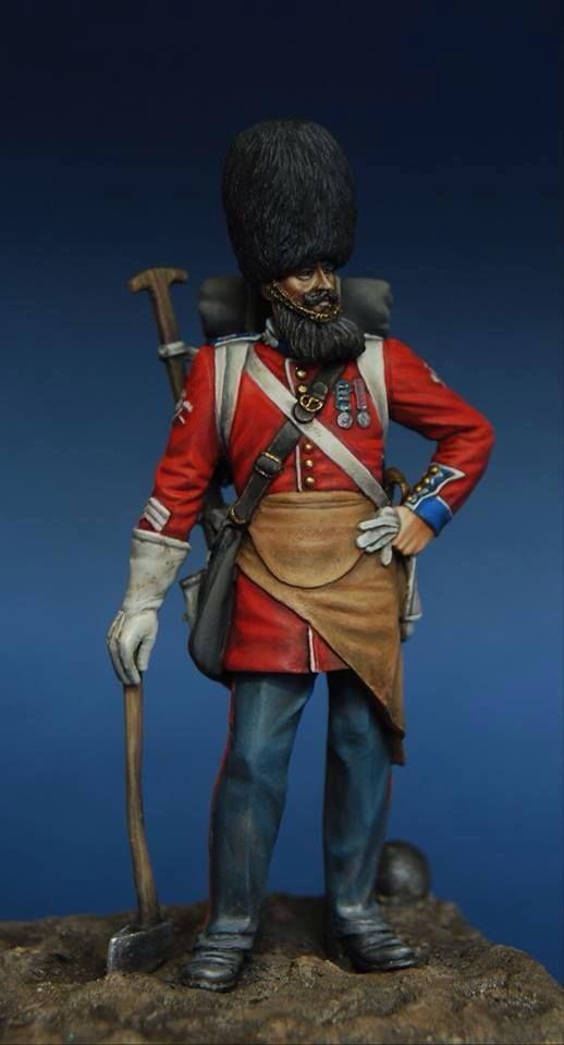 a figurine of a man in uniform with a cane and hat on top of a rock