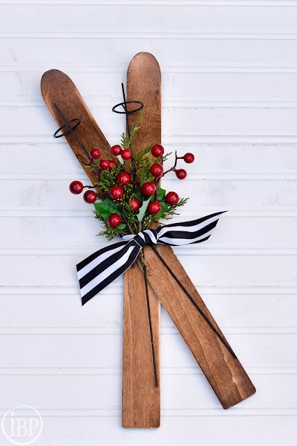 a pair of skis decorated with berries and greenery