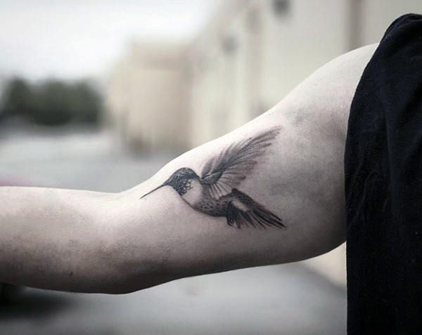 a man with a bird tattoo on his arm