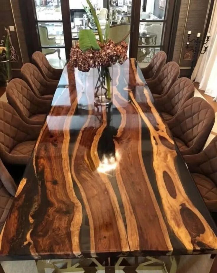 a wooden table with chairs around it and a vase on the table next to it