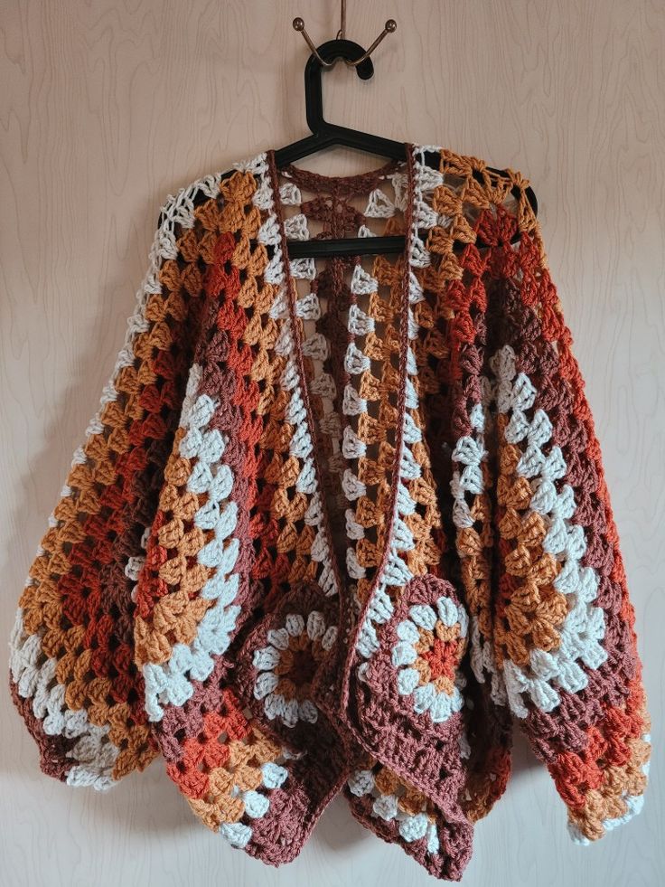 a crocheted jacket hanging on a wall