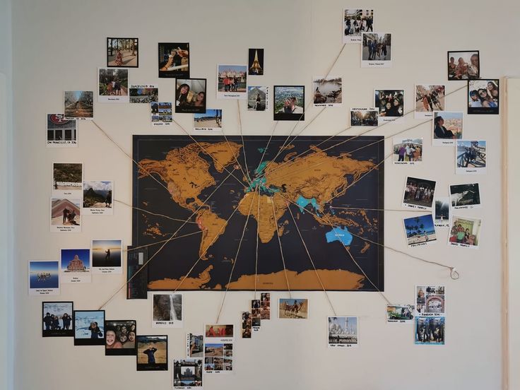 a wall with many pictures on it and a large map hanging from the wall behind it