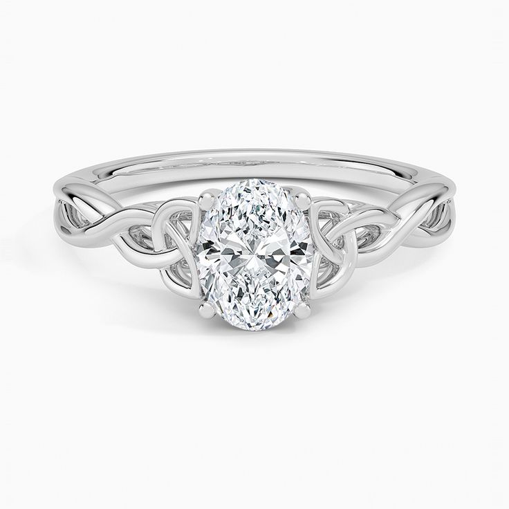 a white gold ring with a oval shaped diamond in the center and an intricate band around it