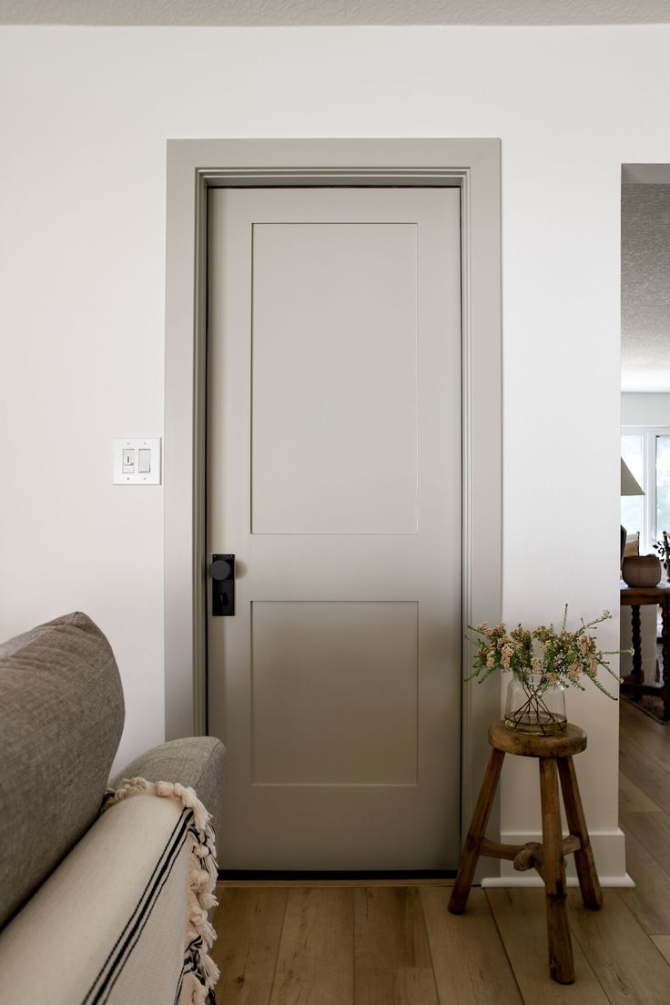 a living room with a couch and a door leading to the dining room in the background