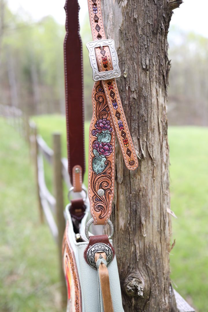 a horse bridle hanging on the side of a tree