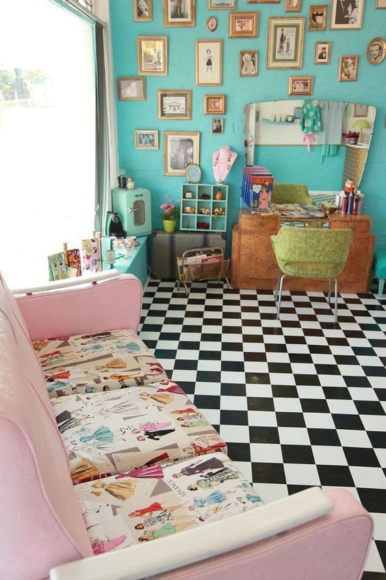 a pink couch sitting on top of a checkered floor in front of a blue wall