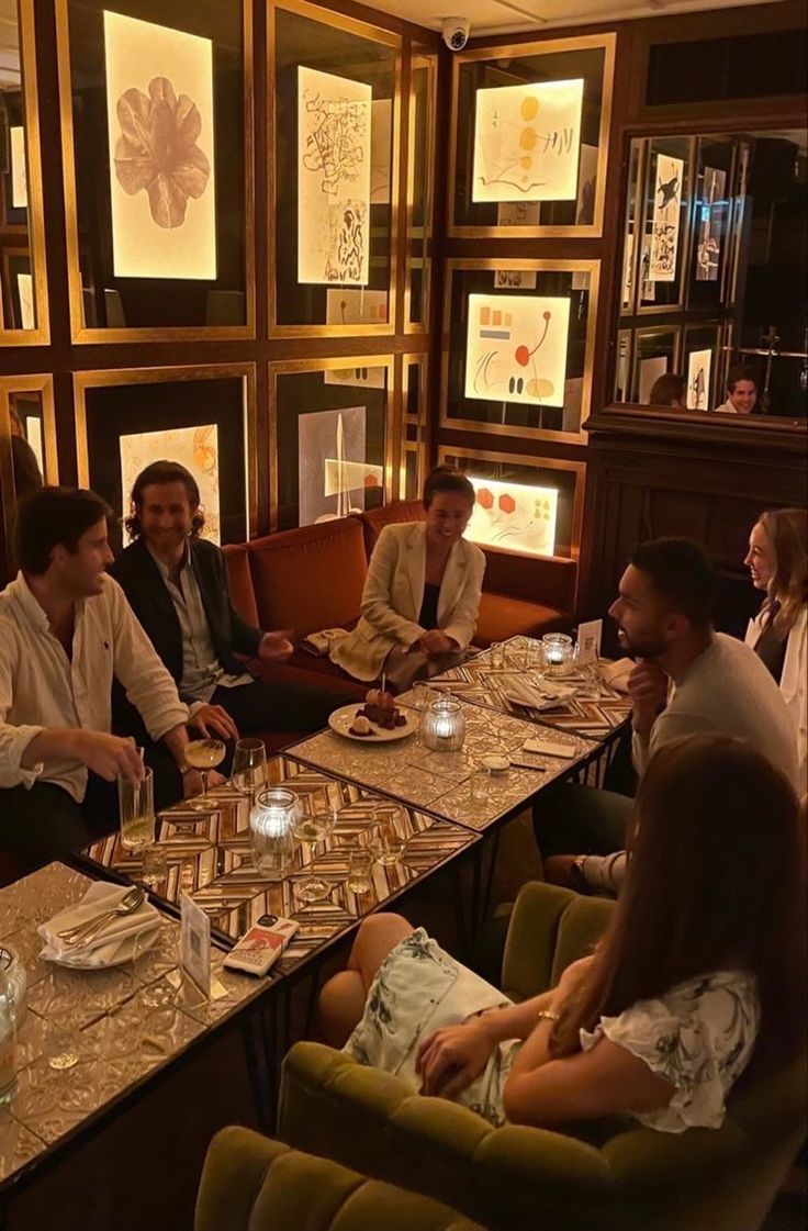 a group of people sitting around a table with plates and glasses in front of them