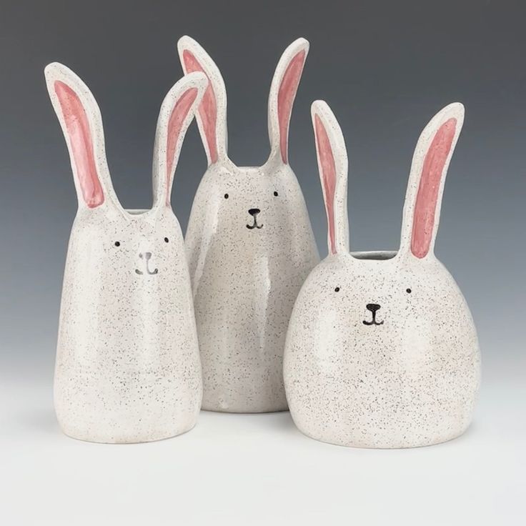 three white ceramic rabbits with pink ears