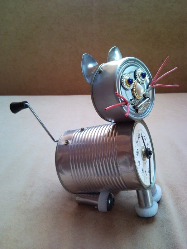 a clock made to look like a cat sitting on top of a tin canister