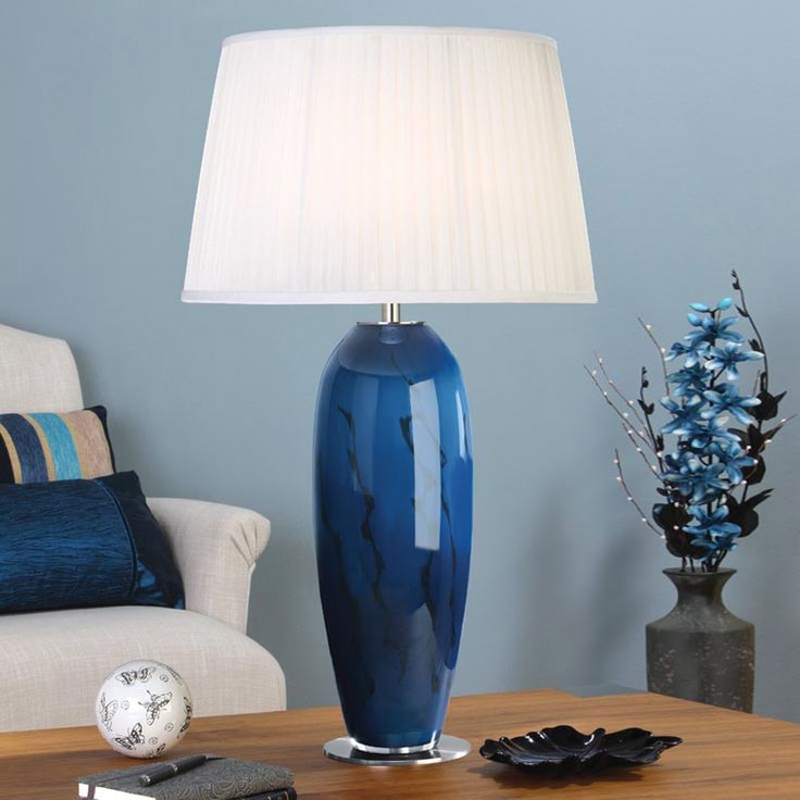 a blue vase sitting on top of a table next to a lamp