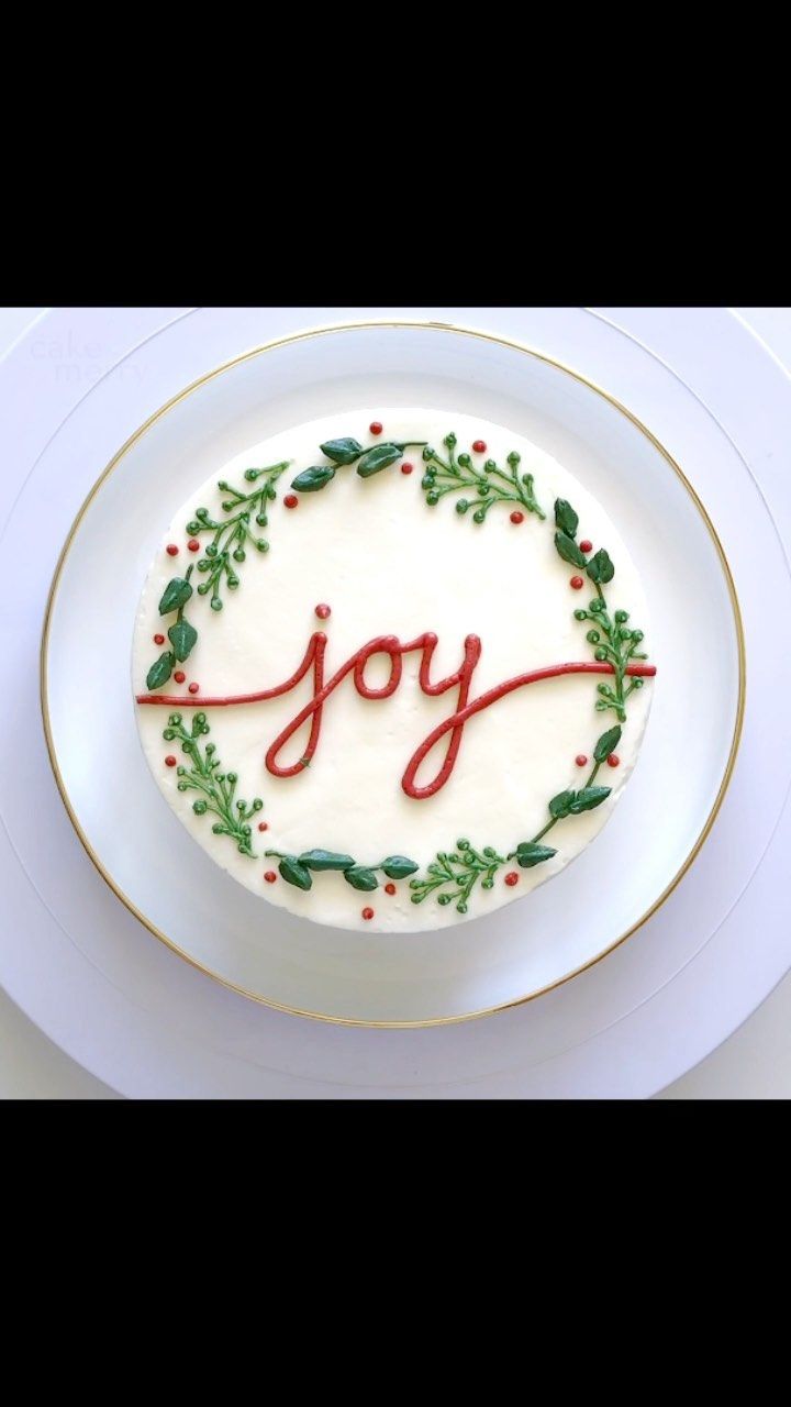 a white plate topped with a cake covered in icing and holly leaves on top of it