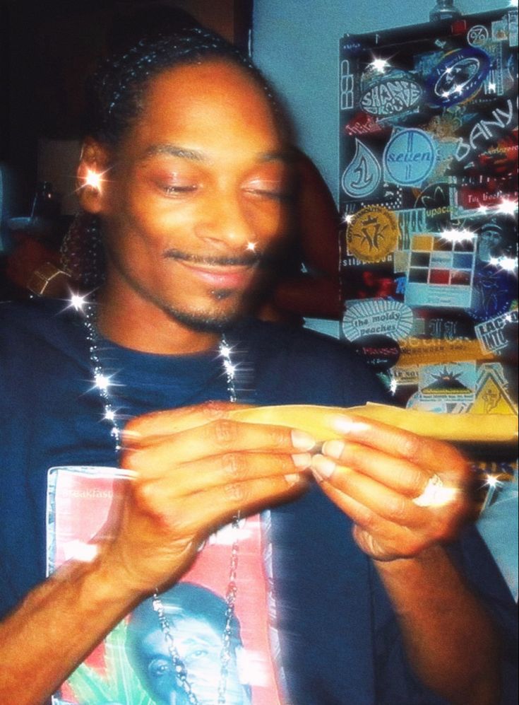 a man smiles while holding a banana in his hands