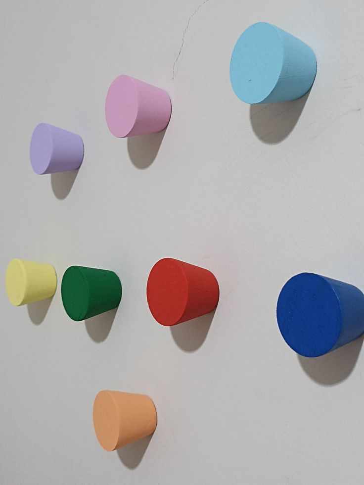 several different colored pieces of paper on a white surface with one piece missing from the wall