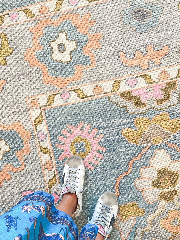 a person standing on top of a rug with their feet up in front of them