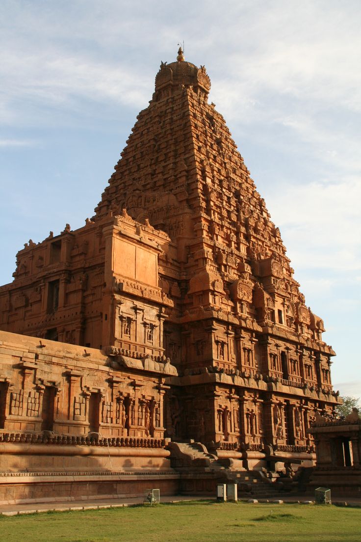 an intricately carved building in the middle of a field