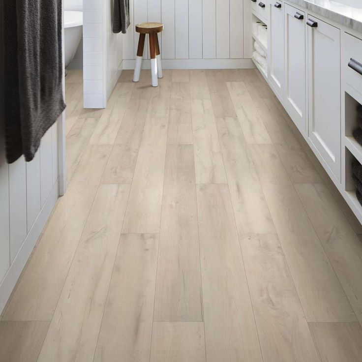 a kitchen with white cabinets and wood flooring on the walls is shown in this image