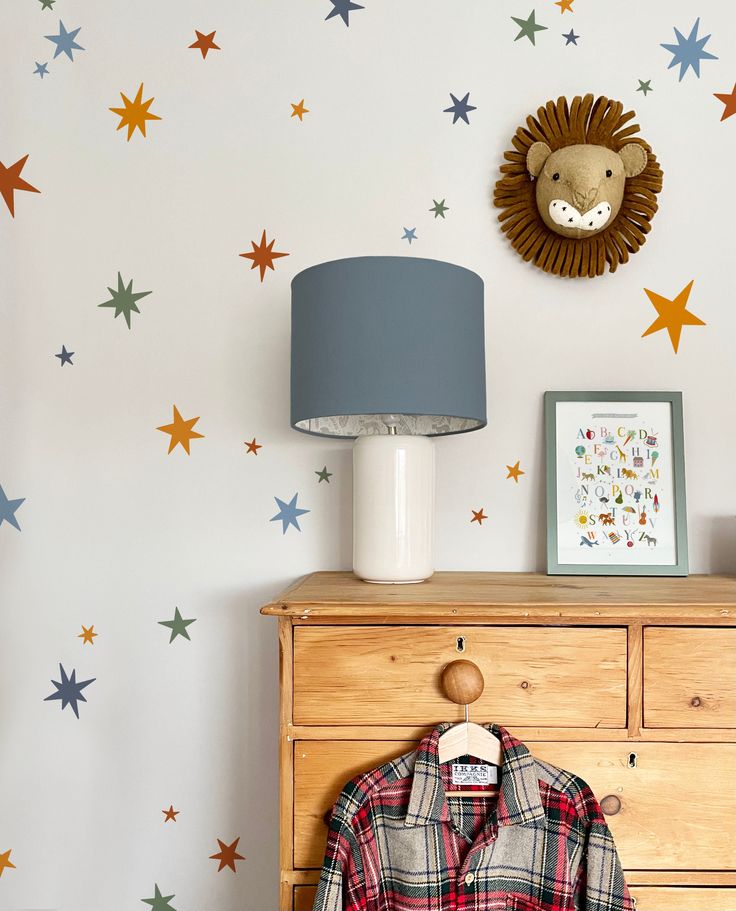 a dresser with a shirt on it next to a wall with stars