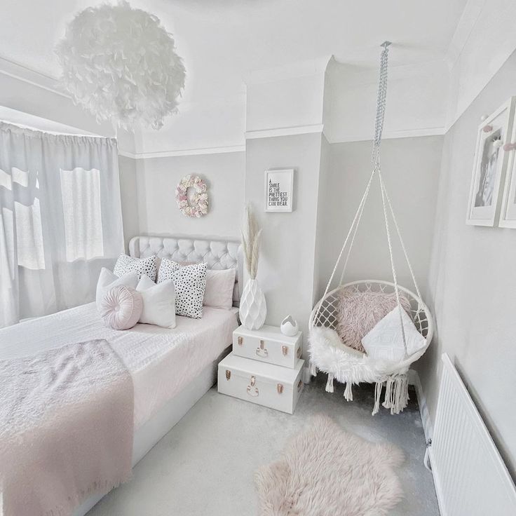 a white bedroom with a hammock hanging from the ceiling and pillows on the bed