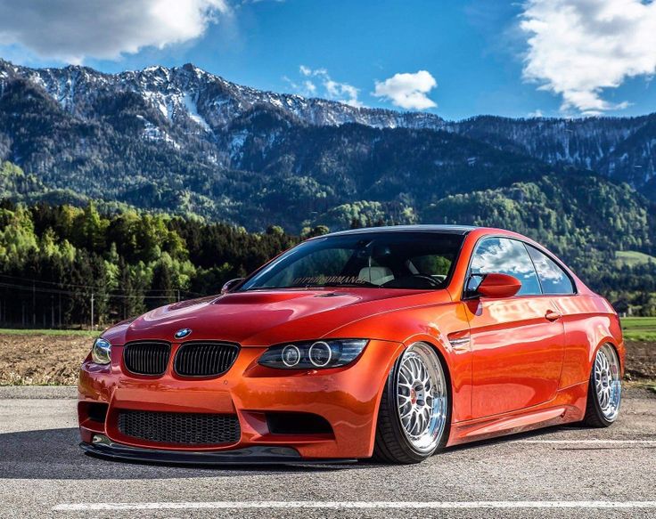 an orange car parked in front of mountains