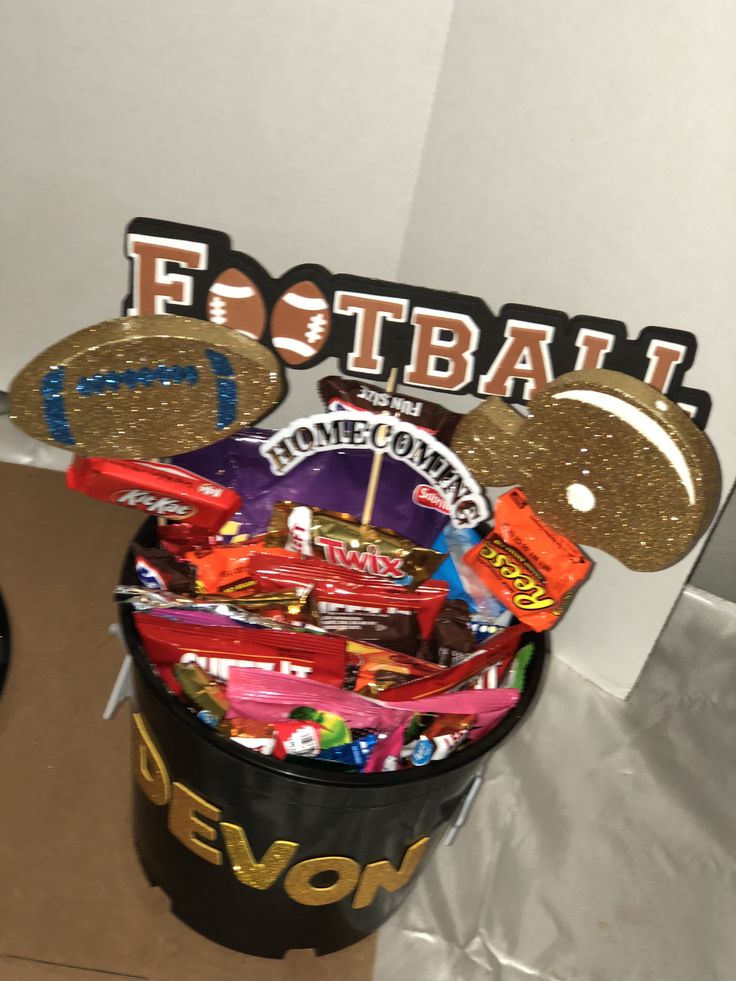 a mickey mouse basket filled with candy and candies in front of a football sign