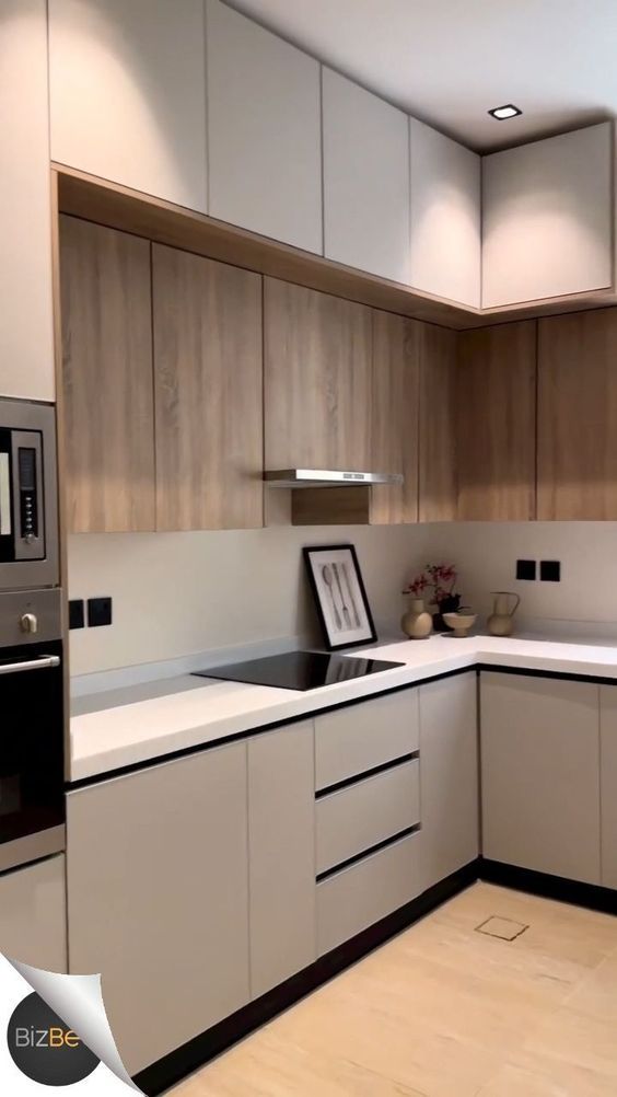 a modern kitchen with white cabinets and wood flooring is pictured in this image from the front view